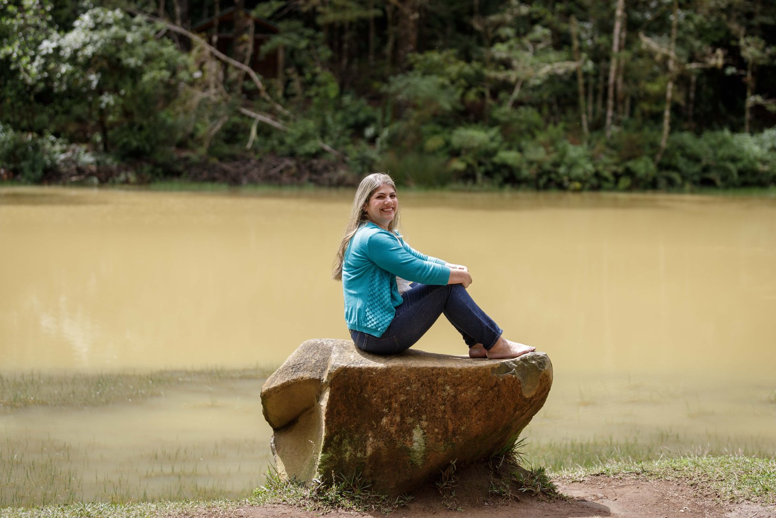 Mar sentada sobre una roca junto al agua